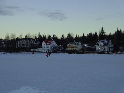Family ice skating on a frozen pond.