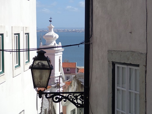 Little surprises like this glimpse of the sea are part of the delights of exploring the Alfama district.